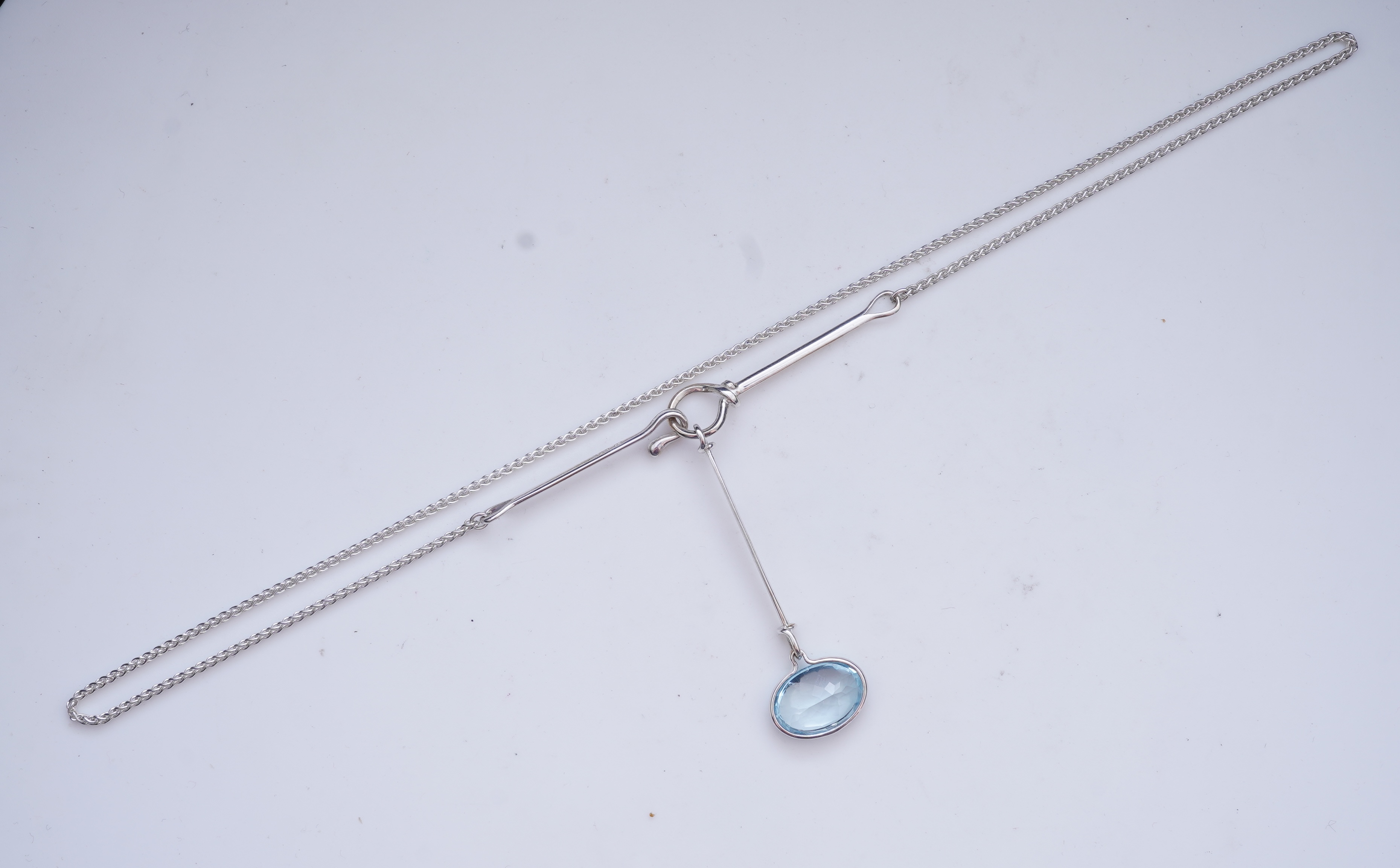 Georg Jensen, a blue topaz necklace, centring on a hook clasp suspending an oval blue topaz pendant, pendant length 5.5cm, necklace length 43cm, stamped GJ for Georg Jensen, 925S and European convention assay marks for s